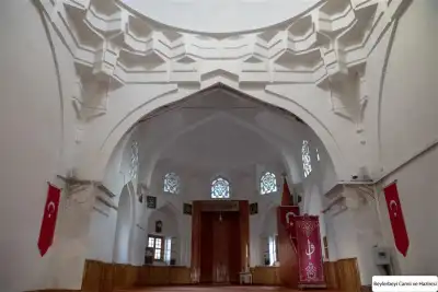 Interior view of Beylerbeyi Mosque featuring the mihrab area adorned with a Turkish flag
