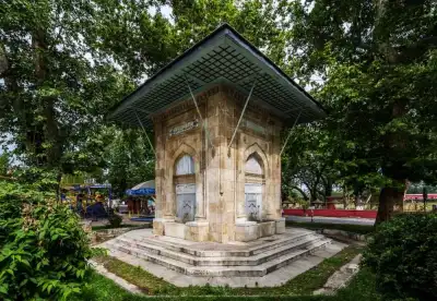 Hacı Adil Bey Çeşmesi yeşil yapraklı ağaçlarla çevrili