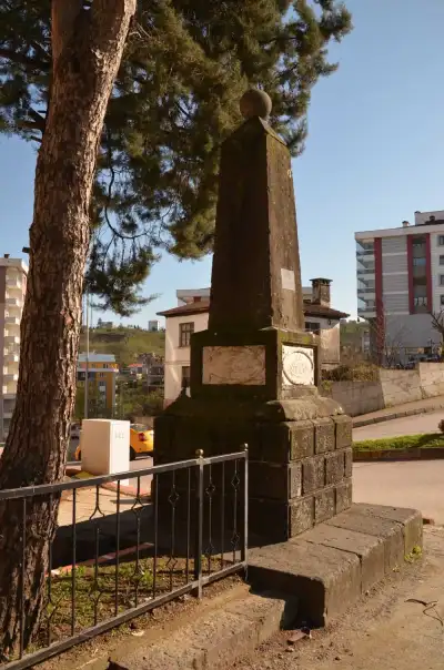 Nihat Bey Anıtı modern şehir arka planında taş anıt