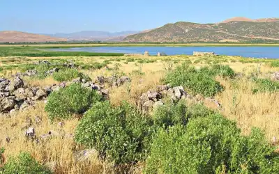 Limenia Adası gölü çevreleyen yeşil otlaklar ve kayalar